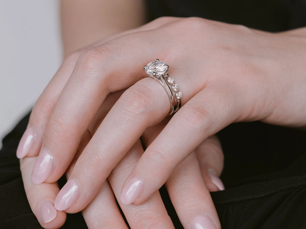 Close-up of a hand wearing a diamond ring with a blurred background