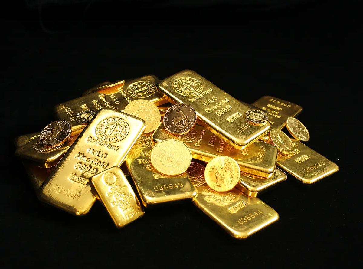 A pile of gold bullion bars and gold coins on a solid black background.