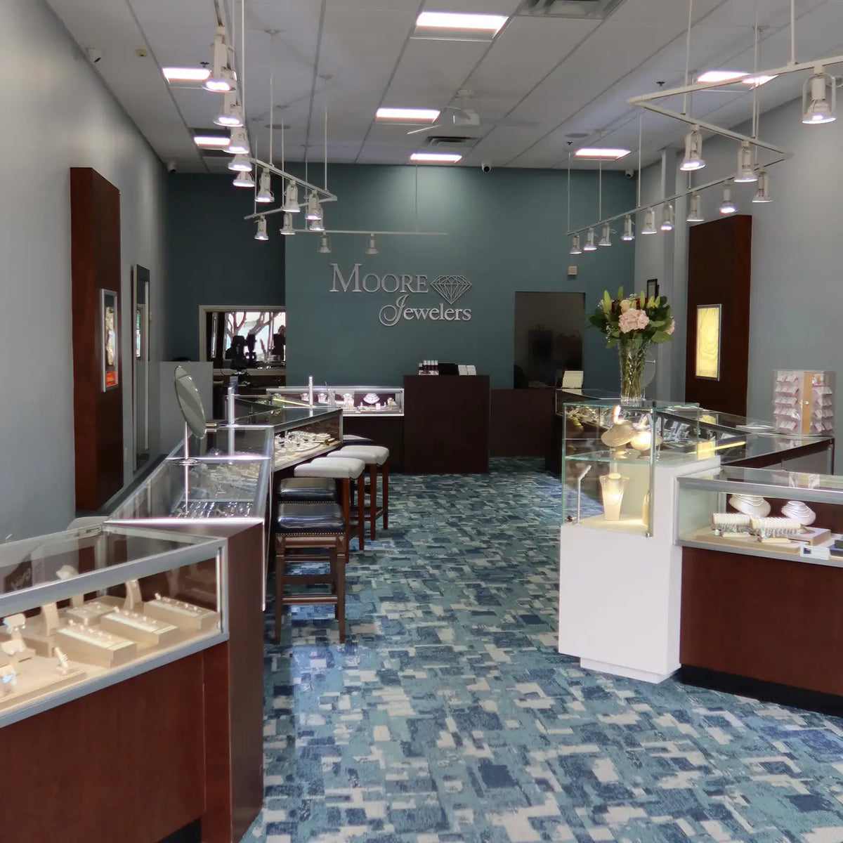 Jewelry store interior with display cases and 'Moore Jewelers' sign.